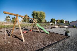 a playground with a green slide in a yard at L-Appartements in Burgau