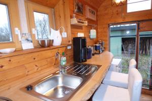 una cocina con fregadero en una cabaña de madera en Zirkuswagen nahe Ostsee und Schlei, en Wagersrott