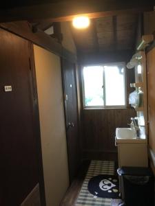 a small bathroom with a sink and a window at Minshuku Hiroshimaya in Kumamoto