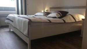 1 dormitorio con 1 cama con marco de madera en Ferienwohnungen Kolsdorf A, en Braunlage