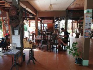 a man and woman sitting at a table in a restaurant at Chian Guesthouse in Chiang Rai