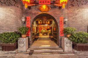 an entrance to a building with an archway with plants at Pingyao Harmony Hotel in Pingyao