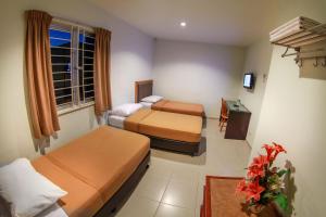 um quarto de hotel com duas camas e uma televisão em Hotel Rembia em Rembia