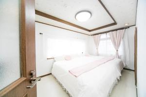Una cama o camas en una habitación de Miraie Yokkaichi Kitahamacho