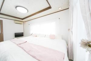 Una cama o camas en una habitación de Miraie Yokkaichi Kitahamacho