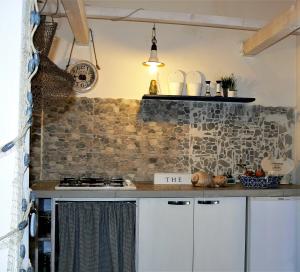 uma cozinha com um balcão e uma parede de pedra em AMURIMARI Catania em Catânia