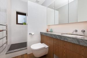 a white bathroom with a toilet and a sink at Newton Heights in Akaroa