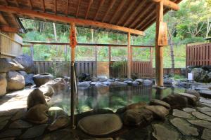 uma piscina de água com pedras num pavilhão em Kawacho em Shizukuishi