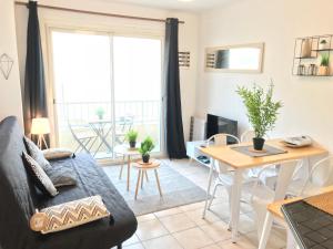 un salon avec un canapé et une table dans l'établissement Superbe ! Appart T3 - Vue mer - Garage, à Palavas-les-Flots
