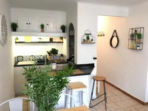 une cuisine avec des armoires blanches et une table avec une plante dans l'établissement Superbe ! Appart T3 - Vue mer - Garage, à Palavas-les-Flots