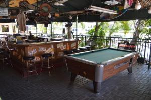 a pool table in front of a bar with stools at Ft. Lauderdale Beach Resort Hotel in Fort Lauderdale