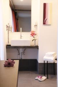 a bathroom with a sink and a counter with flowers on the floor at Hotel Primavera in Saas-Grund