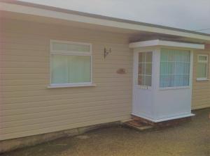 a house with a white door and a window at Angels Corner, Ventnor Bay in Ventnor +5 photos