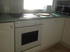 a kitchen with a white stove top oven next to a microwave at Angels Corner, Ventnor Bay in Ventnor