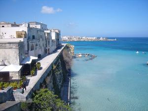 a view of the ocean next to a building at Hotel Blue Sky - San Foca in San Foca