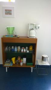
a kitchen area with a refrigerator, microwave, and bookshelf at B&B Oostende in Ostend
