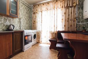 a kitchen with a washing machine and a window at Apartmens Faraon On Illinskaya 5 floor New Building in Sumy