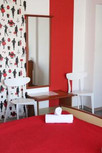 Zimmer mit einem Bett mit einem Spiegel und Stühlen in der Unterkunft Vila Meteor in Cluj-Napoca