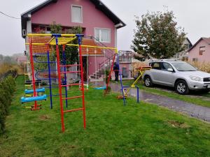 um parque infantil num quintal ao lado de uma casa em Apartments "Predah kod Baraća" em Niš