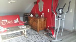 un soggiorno con divano rosso e tavolo di La Maison Bretonne, Chez Pascal & Brigitte a Pleslin-Trigavou