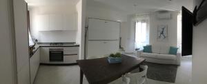Una cocina con una mesa y un refrigerador blanco. en JULES PLACE, en Lecco 4 fotos más