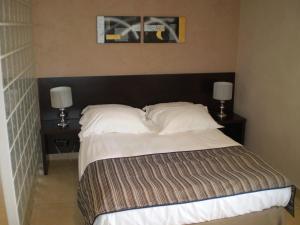 1 dormitorio con 1 cama grande y 2 mesitas de noche en Augustin Marie, en Bonifacio
