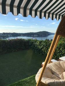 einen Stuhl unter einem Schirm mit Blick auf das Wasser in der Unterkunft La Barmassa in Villefranche-sur-Mer