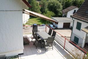a patio with a table and chairs on a balcony at BlackforestBike&HikeHouse in Baiersbronn