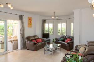 sala de estar con 2 sofás y TV en Samara, en Caleta de Vélez