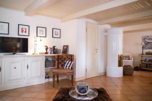 a living room with a tv and a chair at Friesenhaus in Friedrichstadt