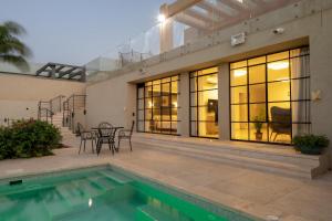 ein Haus mit Swimmingpool und Terrasse in der Unterkunft DesertB in Giv'ot Bar