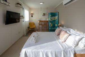 a bedroom with a large white bed and a television at DesertB in Giv'ot Bar