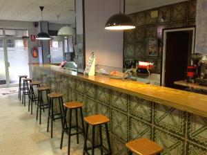 a row of stools at a bar in a restaurant at Hostel Alhambra in Girona