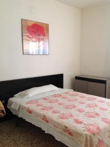 ジローナにあるホステル アルハンブラのベッドルーム1室(花の掛け布団付きのベッド1台付)