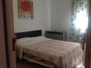 ジローナにあるホステル アルハンブラのベッドルーム1室(ベッド1台、赤と白の毛布付)