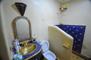 a bathroom with a sink and a toilet with a mirror at Riad Mama H&K in Meknès