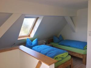 a attic room with two beds and a window at Ferienwohnungsvermietung Leitel in Brandenburg an der Havel