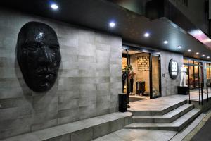 a black mask on the wall of a building at Hotel 88 Shinsaibashi in Osaka