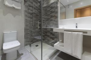 a bathroom with a toilet and a glass shower at Hotel Pradillo Conil in Conil de la Frontera