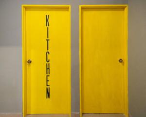 two yellow doors with the words next to each other at Traveller Bunker Hostel 1 in Cameron Highlands