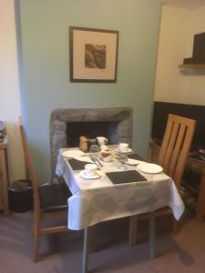 a table and chairs with a table and a fireplace at Garth Engan Private Self Contained B&B with Garden Area in Llanbedr