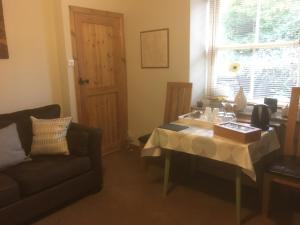 a living room with a table and a couch at Garth Engan Private Self Contained B&B with Garden Area in Llanbedr