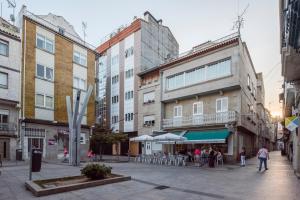 a city street with tables and chairs and buildings at Hotel Airiños 3* in Cangas de Morrazo