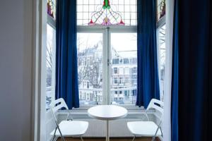 mesa y sillas en una habitación con ventana en Hotel Titus City Centre en Ámsterdam