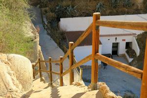 Cueva Alcázar في Gorafe: سور خشبي أمام مبنى أبيض
