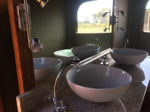 a bathroom with three sinks and a large mirror at Hillcrest Lodge Tents - Sandstone in Plettenberg Bay