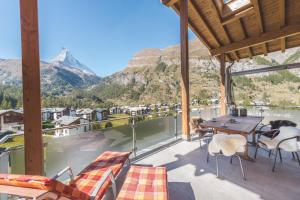 balkon ze stołem, krzesłami i górami w obiekcie Apartment Alpharmonie w mieście Zermatt