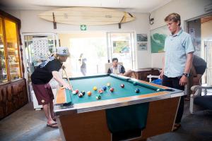 a group of people standing around a pool table at Ansteys Beach Self Catering Apartments in Durban