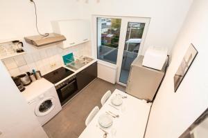 ブレーマーハーフェンにあるAVR Apartment HOF 11の小さなキッチン(洗濯機、乾燥機付)