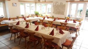 a room with tables and chairs with red napkins on them at Hotel Restaurant Edelweiss in Mühlen